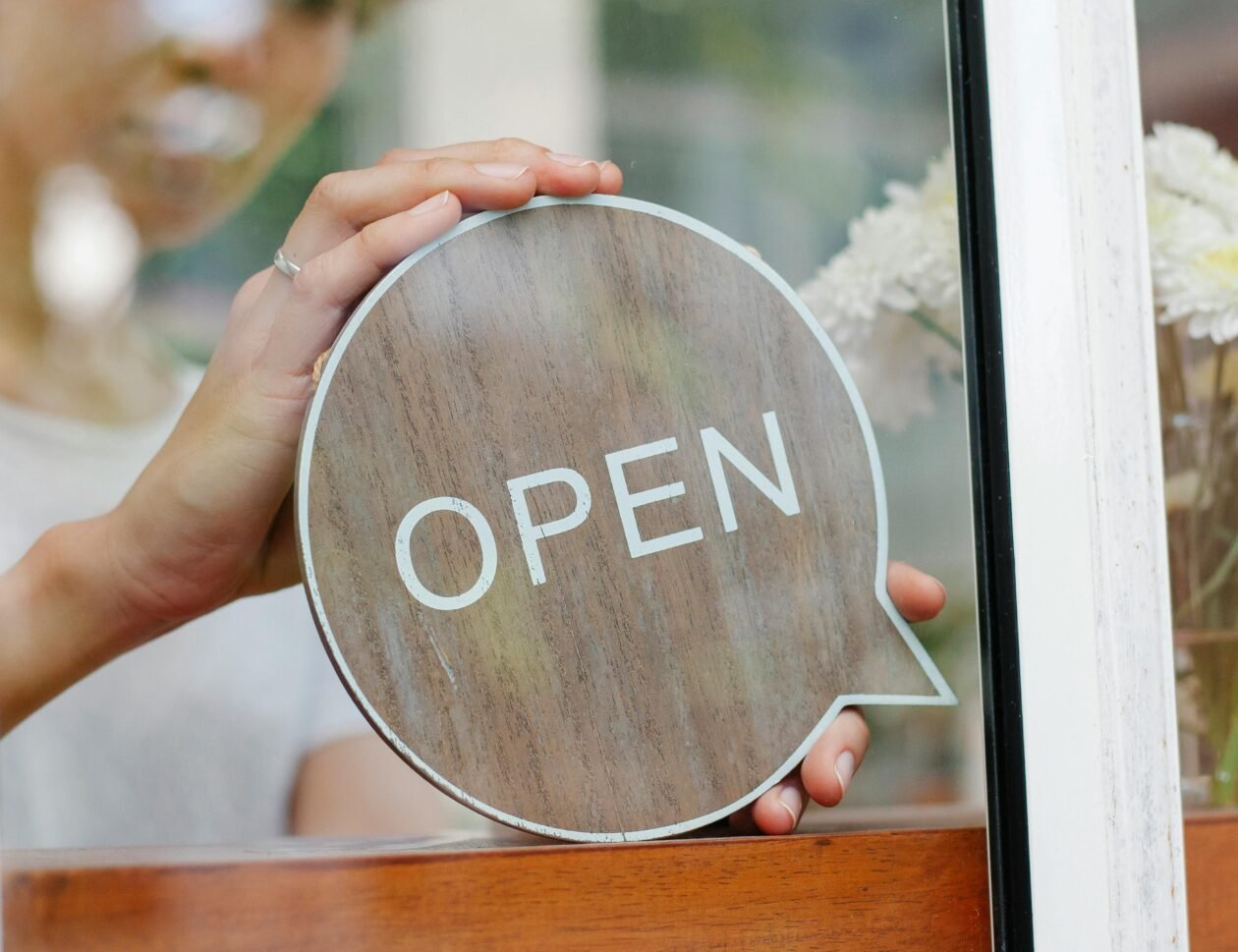 Hands holding circle sign with the work OPEN in a window. Ultimate Guide to Starting a Business