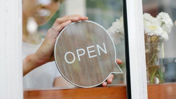 Hands holding circle sign with the work OPEN in a window. Ultimate Guide to Starting a Business